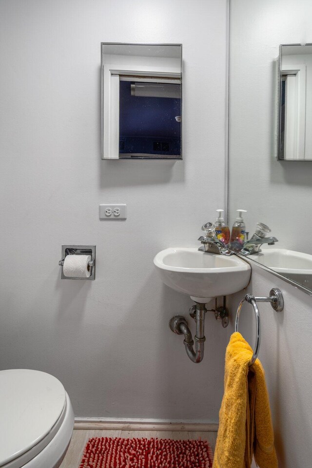 3586 E Huron River Dr, Ann Arbor, MI 48104 - half bathroom featuring a sink, toilet, and baseboards