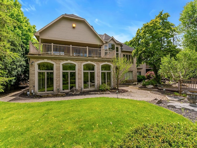 back of house with a yard and a balcony