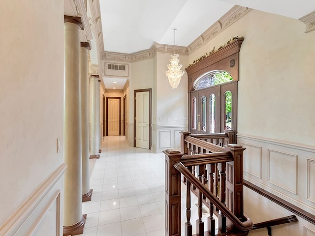 hall with a notable chandelier, light tile patterned floors, and a high ceiling