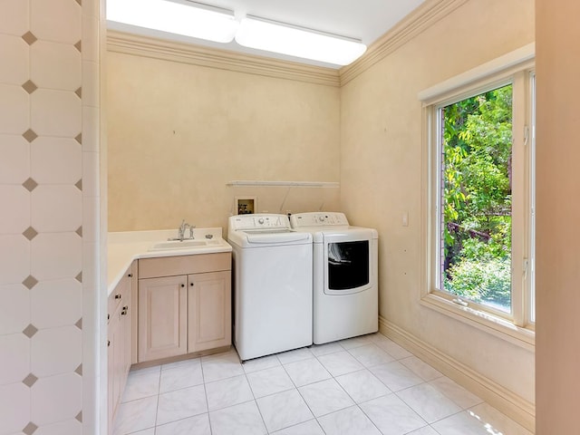 laundry area featuring washer and dryer, cabinets, sink, and a wealth of natural light