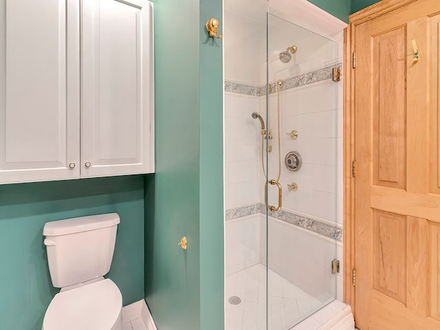 bathroom with a shower with shower door and toilet