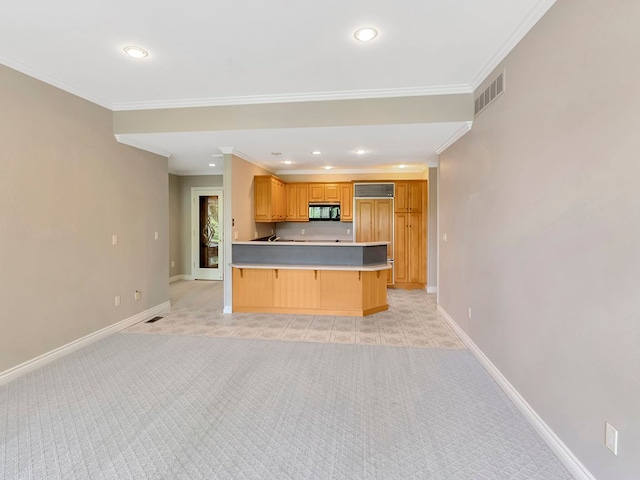 kitchen featuring a breakfast bar area, light carpet, paneled built in refrigerator, and ornamental molding