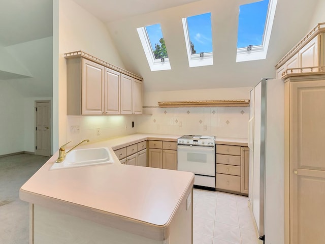 kitchen with plenty of natural light, kitchen peninsula, vaulted ceiling with skylight, and white appliances