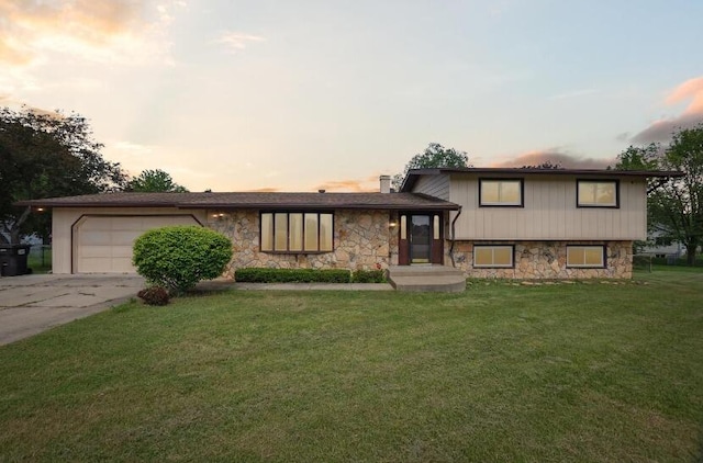 split level home featuring a yard and a garage