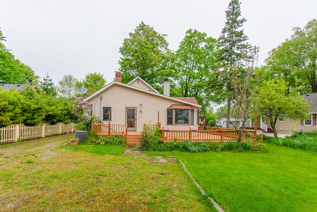 rear view of house with a lawn and a deck