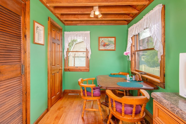 dining area featuring beam ceiling, plenty of natural light, and light wood-type flooring