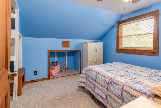 bedroom featuring ceiling fan, vaulted ceiling, light colored carpet, and a closet