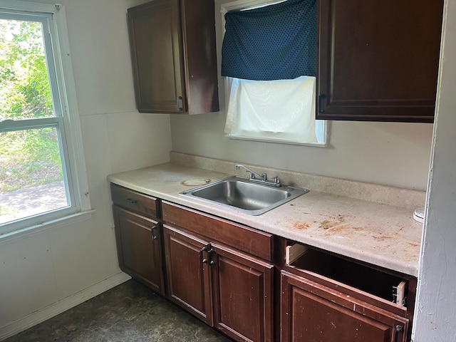 kitchen with a healthy amount of sunlight, dark brown cabinetry, and sink