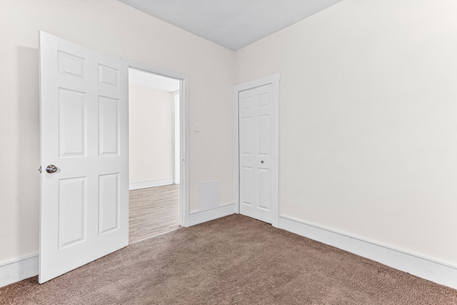 unfurnished bedroom with carpet flooring and a closet