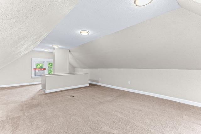 bonus room featuring lofted ceiling, carpet, and a textured ceiling