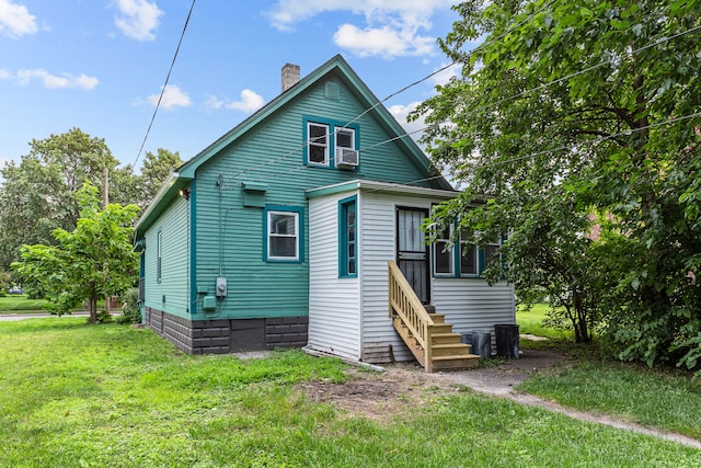 back of property featuring a yard and cooling unit