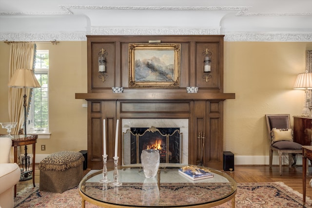 sitting room featuring a high end fireplace and hardwood / wood-style flooring