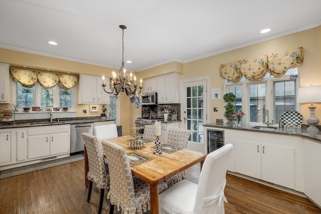 dining area featuring crown molding, sink, and dark wood-type flooring