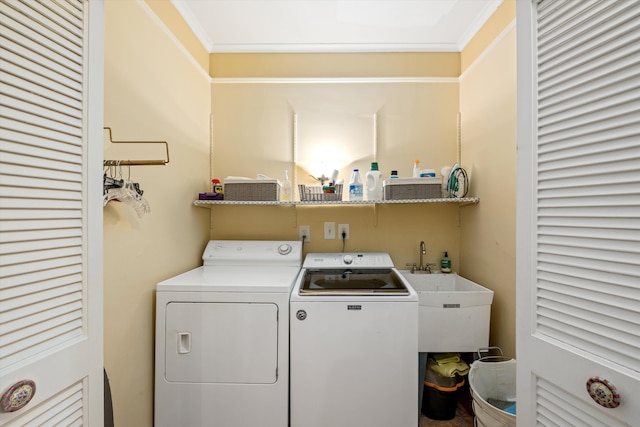 laundry area featuring washer and clothes dryer, crown molding, and sink