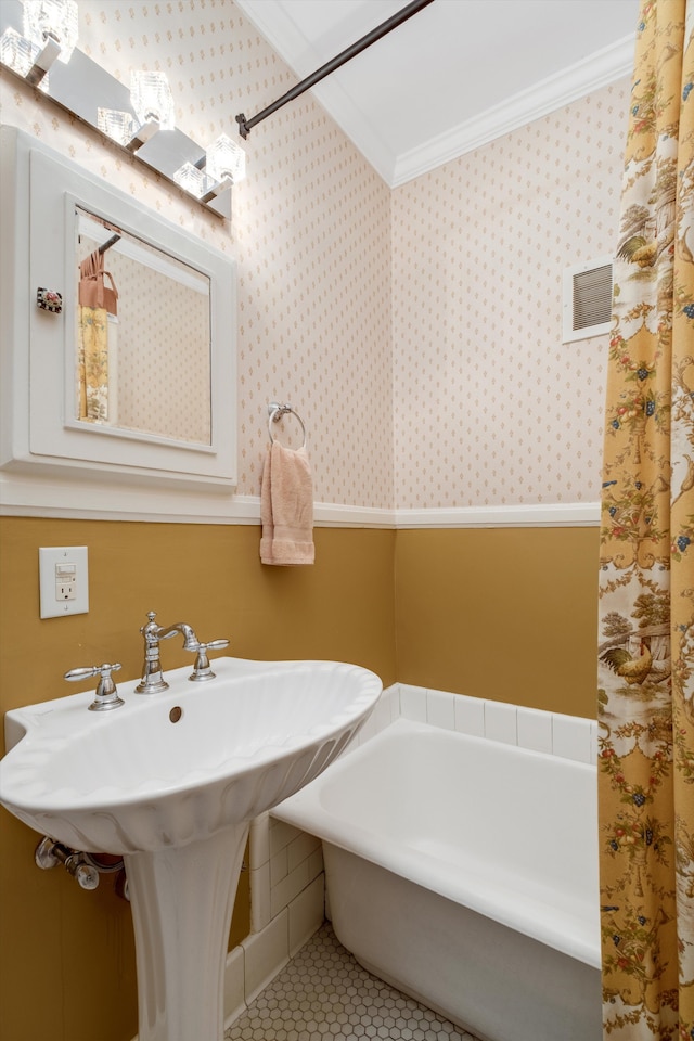 bathroom with tile patterned floors, ornamental molding, and a tub