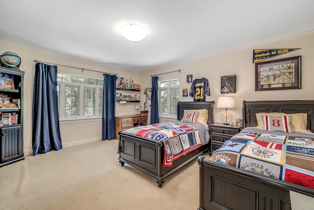 bedroom with ornamental molding and light carpet