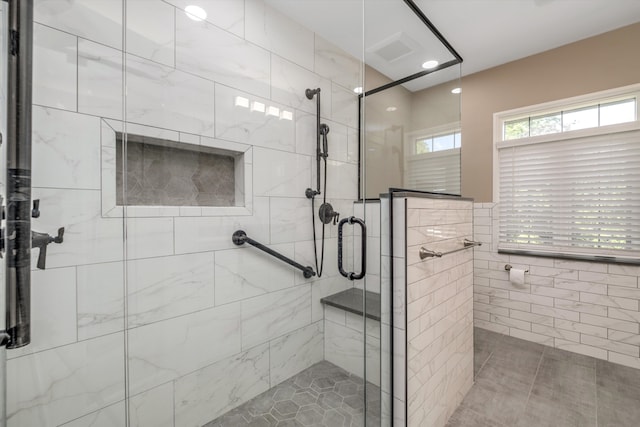 bathroom with tile patterned floors, walk in shower, and tile walls