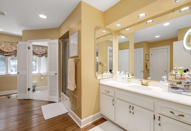 bathroom featuring hardwood / wood-style floors, vanity, and shower / bath combination with glass door