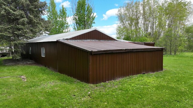 7200 E Tomah Rd, Mount Pleasant, MI 48858 - view of side of home with a yard, an outbuilding, and metal roof