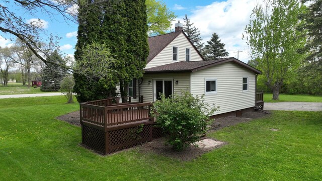 7200 E Tomah Rd, Mount Pleasant, MI 48858 - back of property featuring a shingled roof, a deck, a yard, and a chimney