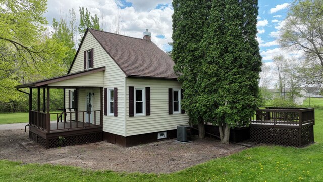 7200 E Tomah Rd, Mount Pleasant, MI 48858 - rear view of property featuring covered porch, central AC, a shingled roof, a chimney, and a yard