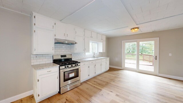 7200 E Tomah Rd, Mount Pleasant, MI 48858 - kitchen with stainless steel gas range oven, under cabinet range hood, tasteful backsplash, and baseboards
