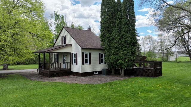 7200 E Tomah Rd, Mount Pleasant, MI 48858 - back of house featuring a porch, a shingled roof, a yard, a chimney, and cooling unit