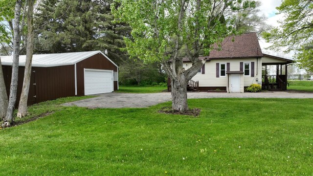7200 E Tomah Rd, Mount Pleasant, MI 48858 - view of grassy yard with a garage, an outbuilding, and asphalt driveway
