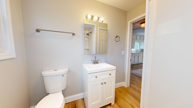 7200 E Tomah Rd, Mount Pleasant, MI 48858 - bathroom with vanity, toilet, wood finished floors, and baseboards
