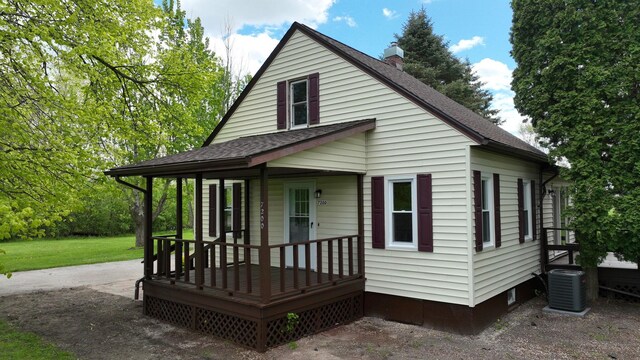 7200 E Tomah Rd, Mount Pleasant, MI 48858 - back of house featuring cooling unit, a shingled roof, covered porch, and a chimney