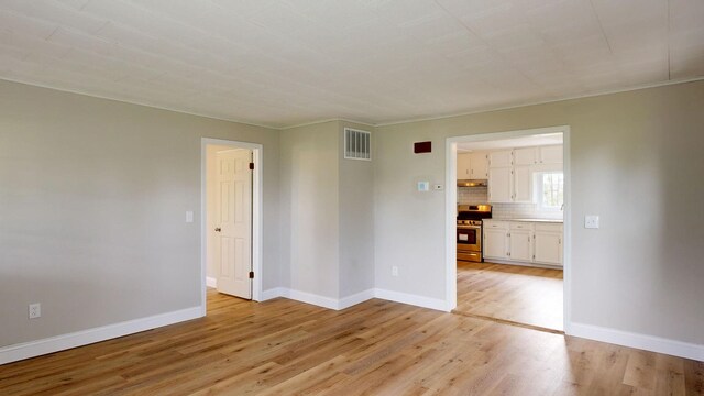 7200 E Tomah Rd, Mount Pleasant, MI 48858 - spare room with light wood-style flooring, baseboards, and a sink
