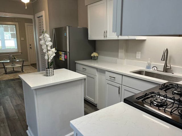 kitchen with dark hardwood / wood-style flooring, a center island, stainless steel refrigerator, and sink