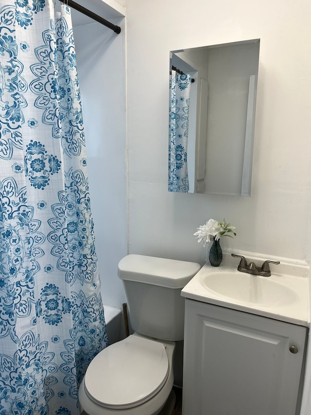 bathroom featuring walk in shower, vanity, and toilet