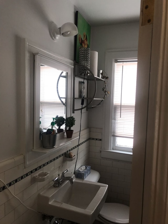 bathroom featuring sink, tile walls, plenty of natural light, and tasteful backsplash