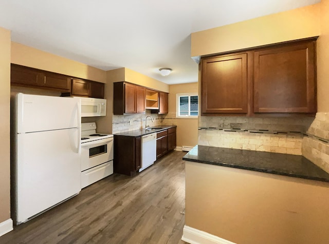 kitchen featuring sink, tasteful backsplash, dark hardwood / wood-style flooring, dark stone counters, and white appliances