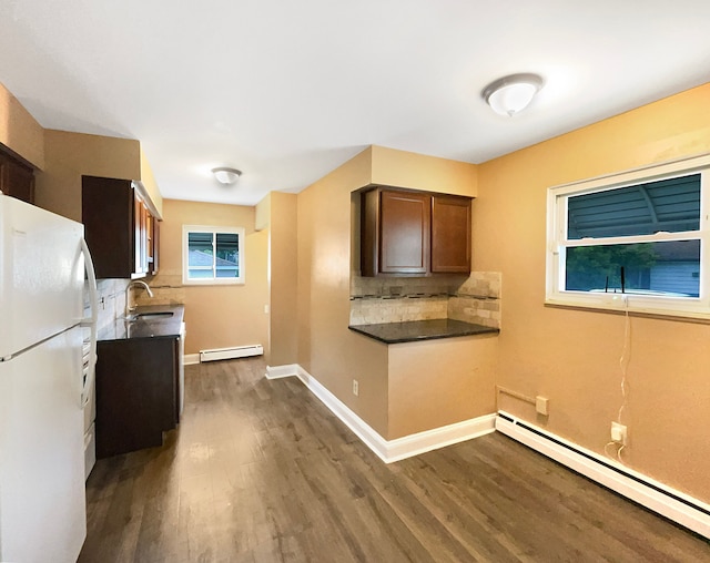 kitchen featuring baseboard heating, decorative backsplash, dark hardwood / wood-style flooring, and white fridge