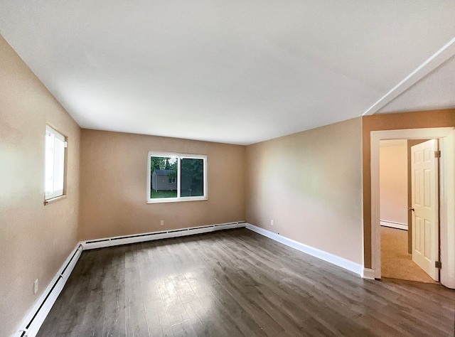 spare room featuring wood-type flooring and a baseboard heating unit