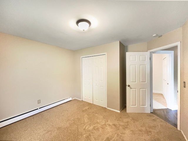 unfurnished bedroom with a closet, light carpet, and a baseboard radiator