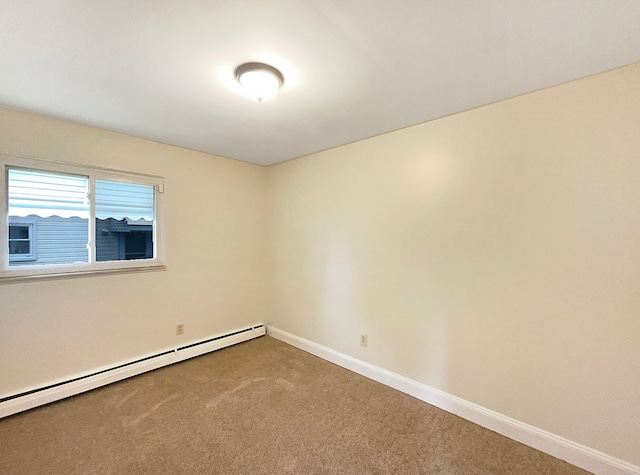 spare room with carpet and a baseboard radiator