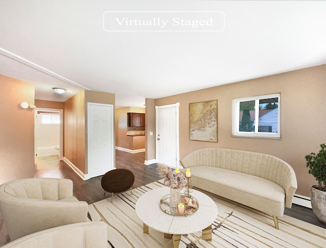 living room with wood-type flooring and a baseboard heating unit