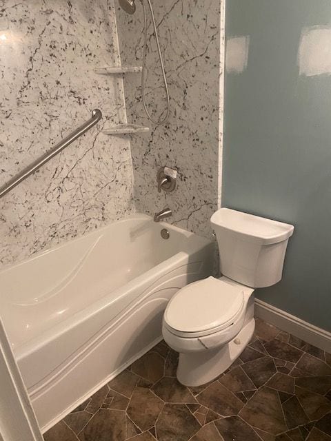 bathroom with tile patterned flooring, toilet, and shower / washtub combination