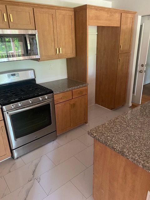 kitchen with stainless steel appliances and dark stone countertops