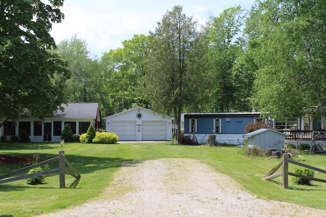 view of front of house featuring a front lawn, an outdoor structure, and a garage