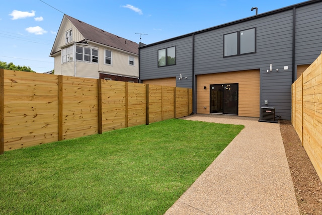 back of house with a lawn, central air condition unit, and a patio area