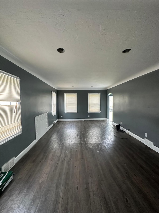 empty room with a textured ceiling and dark hardwood / wood-style floors