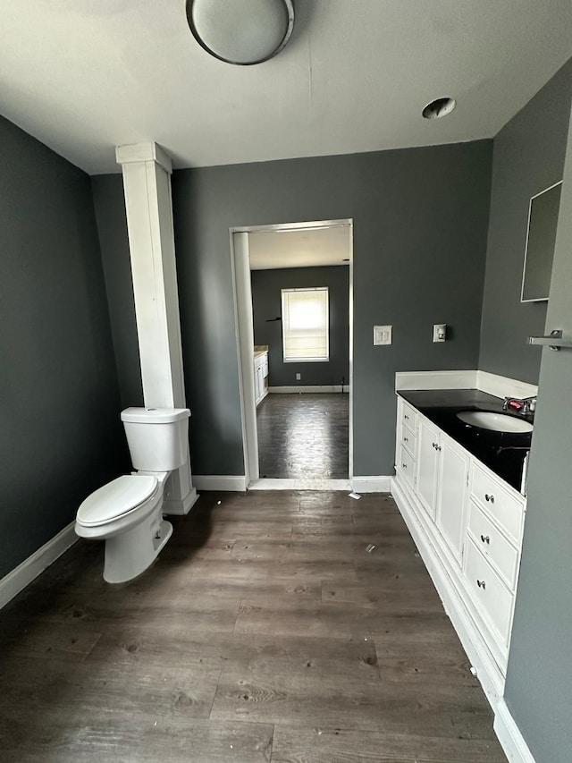 bathroom featuring wood-type flooring, vanity, and toilet