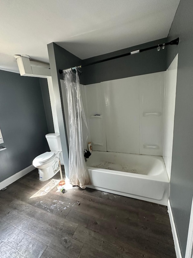 bathroom with hardwood / wood-style floors, shower / bath combination with curtain, and toilet