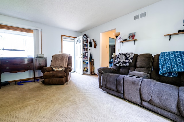 living room featuring light colored carpet and a textured ceiling