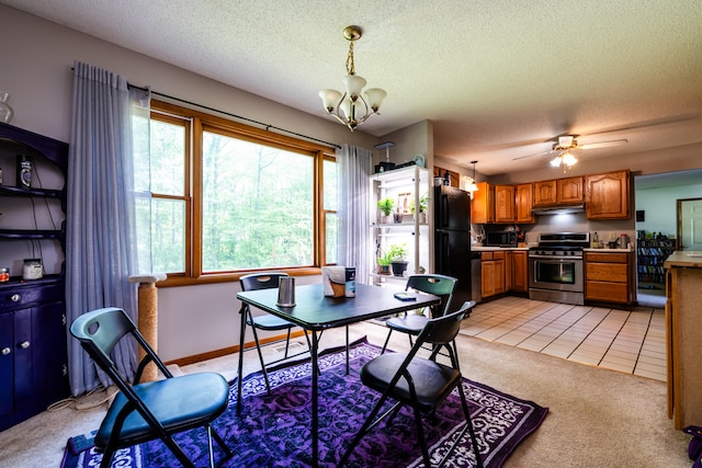 dining area featuring a textured ceiling, light tile patterned floors, and ceiling fan with notable chandelier