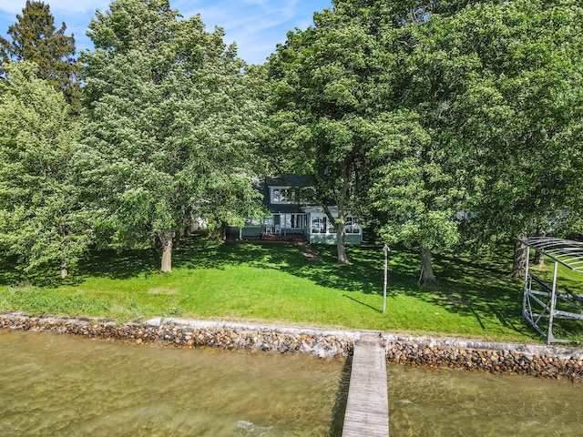 rear view of house featuring a water view and a yard